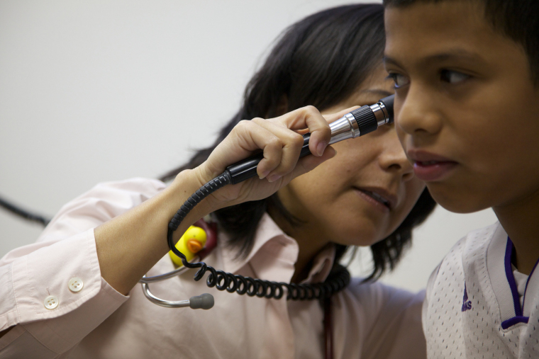 A doctor checks on a young patient. Health care professionals and service providers are building partnerships to help ensure that all families -- including those who experience homelessness -- get access to the care they need. Image courtesy Building Changes via Seattle University School of Theology & Ministry.